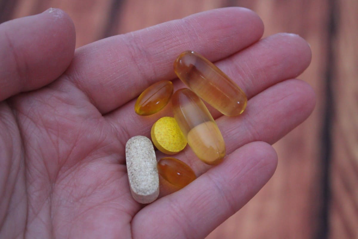 Supplement capsules alongside a meal representing co-administration with food