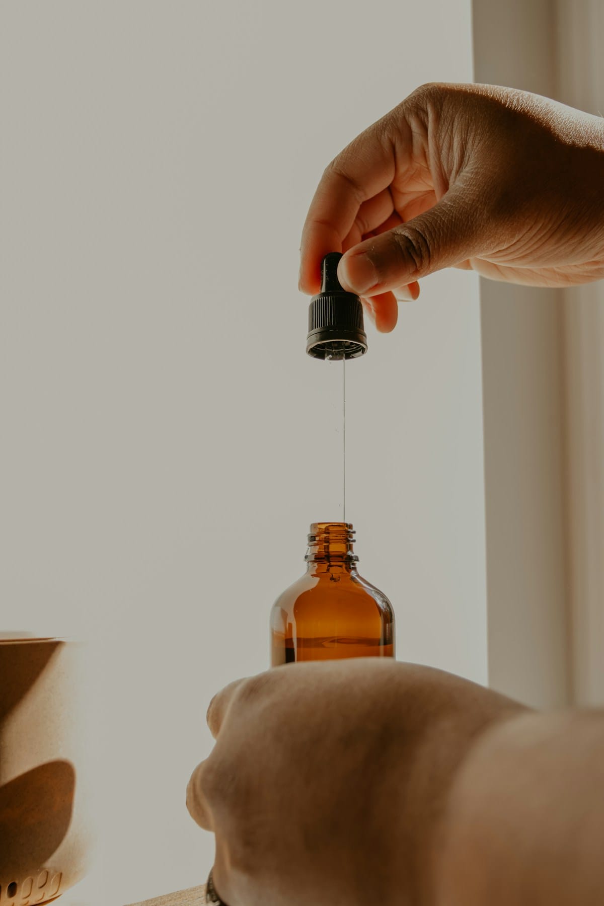 Amber dropper bottle with liquid supplement on a wooden surface