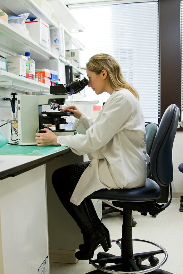 Laboratory researcher examining molecular compounds under controlled conditions