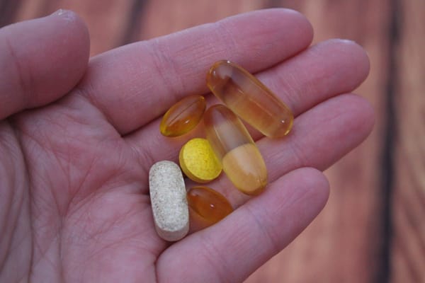 Supplement capsules alongside a meal representing co-administration with food